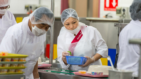 Sodexo catering employees wearing hairnets and masks while preparing food