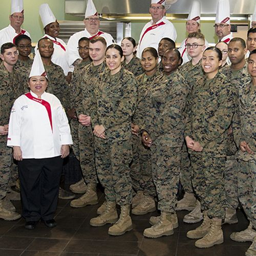 A group of chefs and military personnel standing together